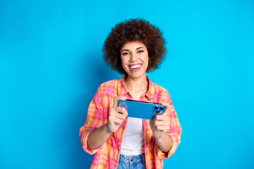 Canvas Print - Photo portrait of lovely young lady play mobile game dressed stylish checkered garment isolated on blue color background