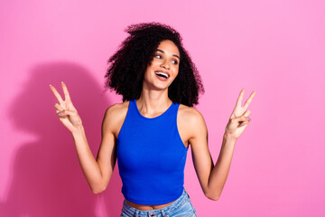 Poster - Photo portrait of lovely young lady show v-sign look empty space dressed stylish blue garment isolated on pink color background