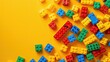 © Nuttaya Nampai - Yellow background with a playful arrangement of toy blocks, symbolizing creativity and childhood.