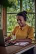 © kerkezz - a girl in a yellow shirt with head phones and a drink working on the laptop