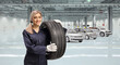 © Ljupco Smokovski - Young woman auto mechanic holding a car tire in a car garage