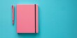 © zishan - Isolated on a blue background with plenty content space, a blank pink notebook and pen, Generative AI.