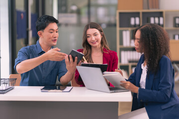 A team of successful Asian business men and women present team meeting minutes and present office collaboration ideas.