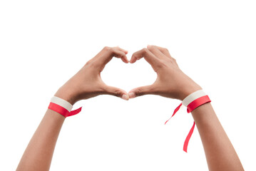 Indonesian independence day theme. A child's hand with a red and white ribbon isolated on a white background