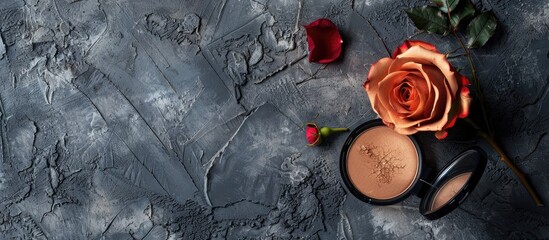 Poster - Close up image with bronzer and rose flower placed on a textured grey surface providing empty space for text. Copy space image. Place for adding text and design