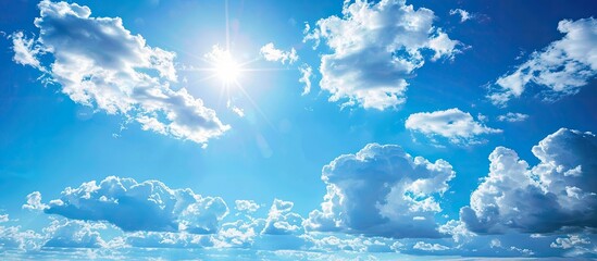 Wall Mural - Clear blue sky with fluffy white clouds on a sunny summer day providing an empty background for a potential copy space image