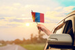 ©  minionionniloy - Waving the Mongolia flag against the sunrise or sunset from a car driving along a country road. Holding the Mongolia flag, traveling by car, on a weekend trip.