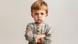 © Adi - Mad male kid, angry little boy standing with his arms crossed, and looking at the camera with upset face expression. Unhappy todler