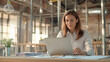 © Катерина Євтехова - a young female manager in a stylish loft office, working on her laptop and organizing paperwork for a project. The loft's industrial design with metal and wood elements provides an