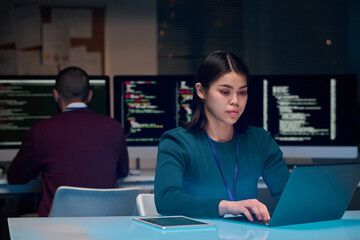 portrait of young woman as software development expert using laptop at minimal office workplace with