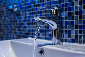 Wall Mural - Modern bathroom washbasin sink with a faucet and a blue tile wall, washroom interior design.