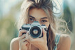 © Karrrtinki - Close-up of a young Caucasian woman holding a camera, taking a photo, outdoors, learning photography