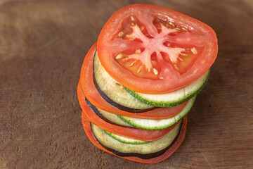 Sticker - Sliced ​​tomato, zucchini and eggplant for ratatouille. Fresh and baked vegetables. Low-calorie diet. French cuisine. Bright vegetables for a summer dish. Vegetable mix.