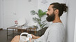 © Krakenimages.com - Handsome bearded hispanic man in a modern room holding headphones, portrays a casual, relaxed atmosphere.