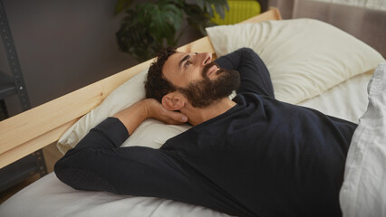 Wall Mural - Handsome bearded man resting peacefully in a modern bedroom, evoking feelings of relaxation and comfort.