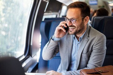 Young business man traveling to work by train, working while traveling, talking on phone. Young business man traveling to work by train.