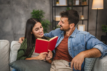 Wall Mural - relax couple boyfriend and girlfriend sit on sofa and read a book