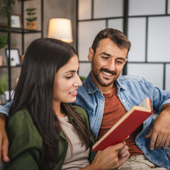 Wall Mural - relax couple boyfriend and girlfriend sit on sofa and read a book