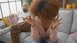 © Krakenimages.com - An upset woman gestures frustration during an argument with a man sitting on a couch in a modern living room.