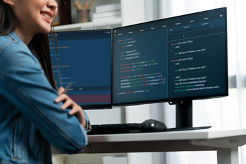 Young beautiful Asian IT developer l looking out to present with online information on pc with coding program data application, wearing jeans shirt. surround by safety analysis two screens. Stratagem.