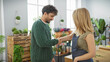 © Krakenimages.com - Two people, a woman and a man, shaking hands in a vibrant flower shop filled with green plants and natural light.