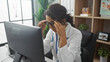© Krakenimages.com - A stressed female healthcare worker at her office within a clinic, visibly overwhelmed in front of a computer screen
