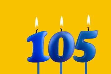 Blue candle number 105 - Birthday on yellow background