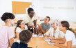 © JackF - African-american man native english speaker teaching different aged group of people to talk fluently. Foreign language courses in classroom.