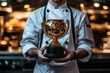 © Infinity Lens - Photograph of a Chef Receiving a Culinary Award: A chef holding a culinary trophy in a restaurant.