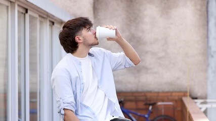 Wall Mural - young man or teenager on the street drinking