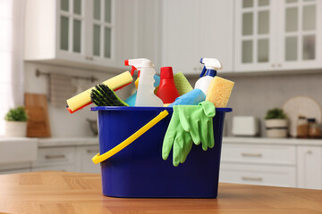 Sticker - Cleaning service. Bucket with supplies on table in kitchen