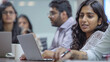 © Chatchanan - Focused Indian businessman working on a laptop while collaborating with colleagues at a meeting table