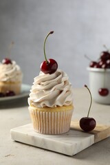 Wall Mural - Delicious cupcake with cream and cherries on light textured table