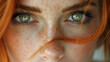 © Steven - Close-up of a young woman's freckled face with striking green eyes and red hair, portraying an intense and captivating expression.