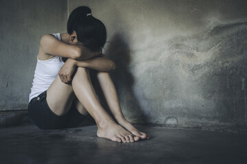 Young woman suffering from depression and anxiety sitting on the floor. The woman feels frustrated and confused, unhappy, personal problems, stress.