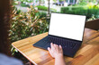 © Farknot Architect - Mockup image of a woman using and touching on laptop computer touchpad with blank white desktop screen in the outdoors