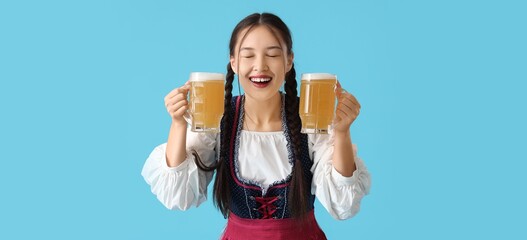 Sticker - Happy young woman with beer on blue background. Octoberfest celebration