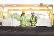 © JU.STOCKER - Engineer and female foreman worker with blueprints and digital tablet checking project at the precast concrete factory site, Engineer team in hardhats discussing on construction site