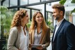 © Boomanoid - Three professionals talking and smiling in office lobby