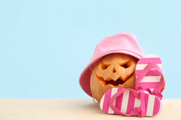 Wall Mural - Carved pumpkin for Halloween with stylish hat and flip-flops on blue background