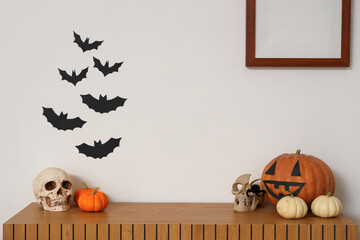 Halloween pumpkins with skull on chest of drawers in living room