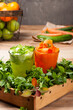© Syphoto - Beautifully decorated freshly prepared carrot and cucumber juice glasses on a tray filled with various edible greens on wooden table  with other fruits and vegetables in the background