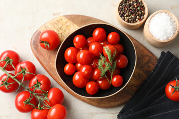 Wall Mural - Tasty pickled tomatoes in bowl, spices and fresh vegetables on light grey table, top view