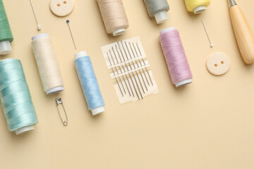 Poster - Flat lay composition with different sewing supplies on beige background. Space for text