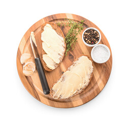 Wall Mural - Wooden board of bread slices with fresh butter, garlic, peppercorn and salt on white background