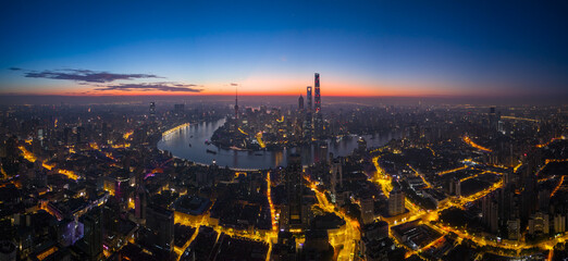 Aerial view of modern city skyline and buildings at sunrise in Shanghai.