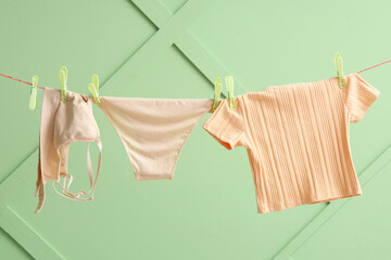 Canvas Print - Clean clothes hanging on rope against color wall