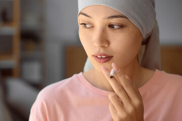 Sticker - Young Asian woman after chemotherapy smoking weed at home, closeup