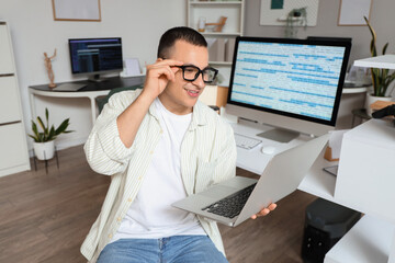 Canvas Print - Handsome programmer working with laptop in office