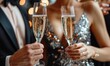 © Georgii - Close-up of man and woman clinking champagne glasses at elegant celebration
